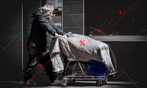 A person with disheveled hair pushes a shopping cart covered in a blanket along a city sidewalk. Overlaid are glitch effects, graph lines, and percentage symbols, suggesting economic or social commentary.