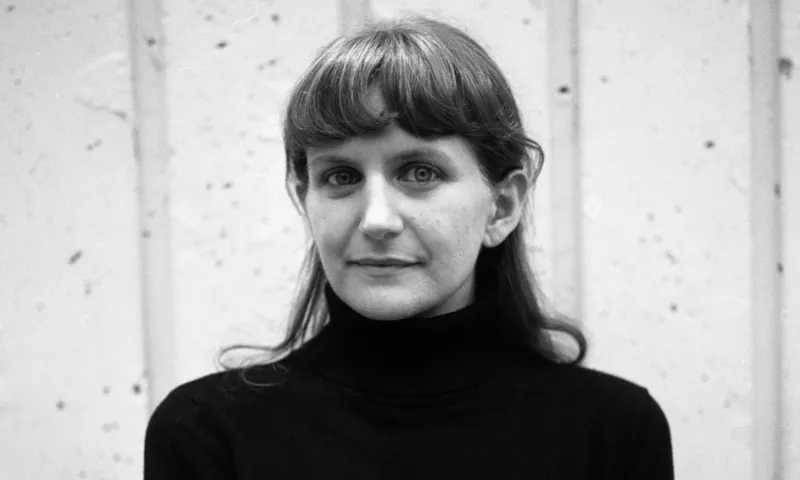 A black and white photo of musician Liz Pelly. She has long hair tied back with a fringe.