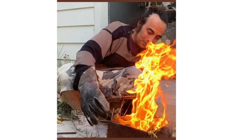 Photo of a man firing an object in flame.