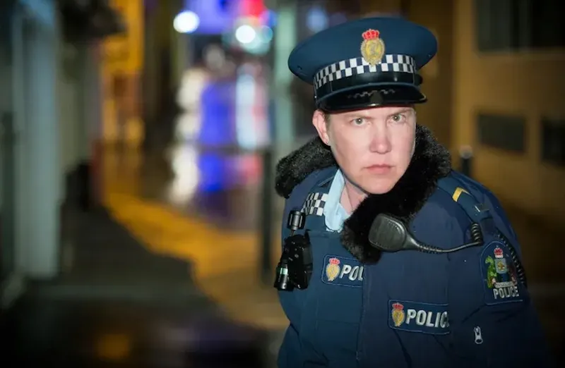 Karen O'Leary in an alleyway, dressed as a police officer, in Wellington Paranormal