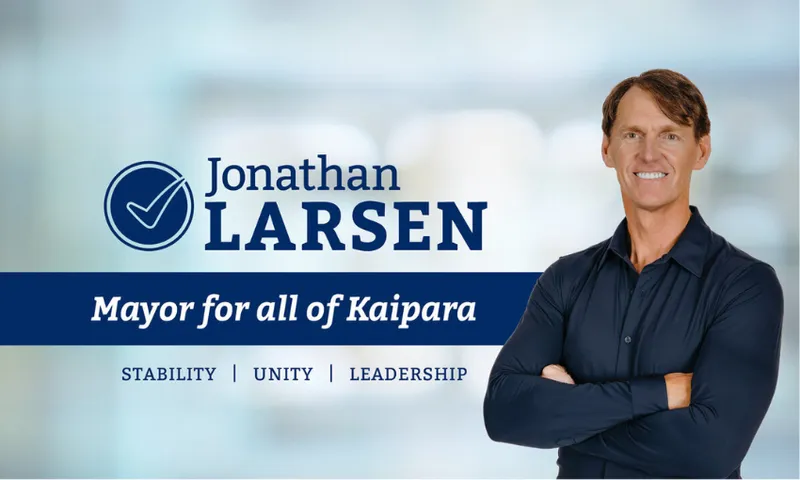 A man in a dark shirt stands smiling with arms crossed next to text that reads "Jonathan Larsen, Mayor for all of Kaipara. Stability | Unity | Leadership" on a blurred blue background.