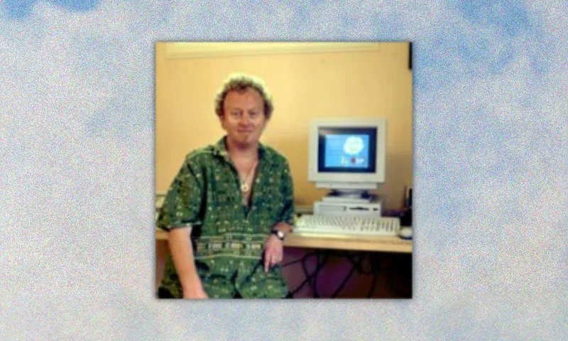an insanely blurry low resolution photo of dave dobbyn posing with a desktop computer in what is unmistakably the mid 1990s