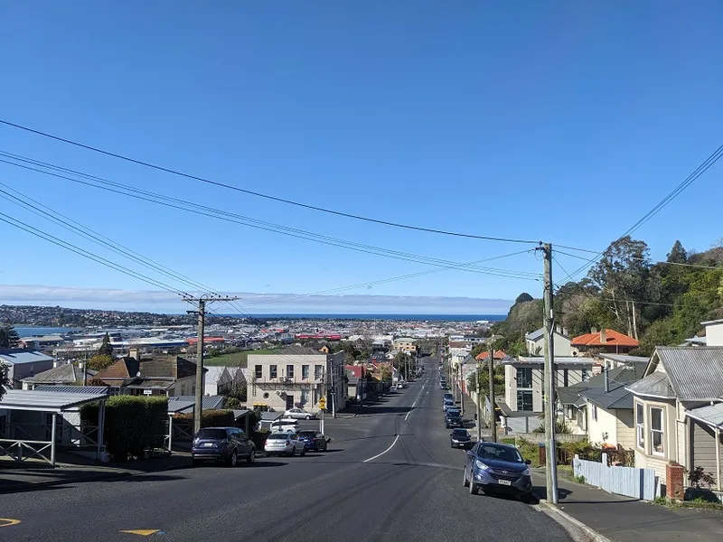 a blue sky and a road stretching to the ocean