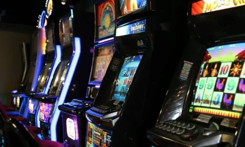 Brightly-coloured pokie machines lined up in a bar.