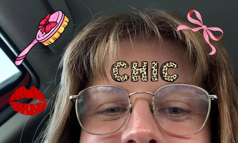 A close up of a fringe sticking straight up into the air, bedazzled with beauty-related stickers