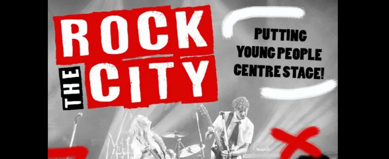 A promotional image for Rock the City which is a showcase of eight youth bands. There is a band in black and white in the background with "Rock the City" in block letters overlaid. There are red "X" symbols in the lower corners.