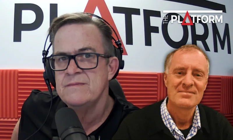 two men, one wearing glasses and headphones and speaking into a microphone, the other in a collared shirt smiling to camera. In the background the logo of "the platform" in red, white and black