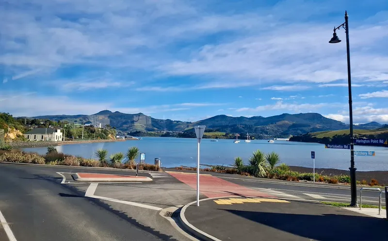 Portobello village in Dunedin, with the road in the foreground and the blue sea in the background