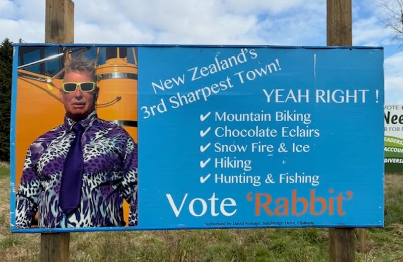 A blue electoral hoarding featuring a man named Rabbit – text reads New Zealand's sharpest town? Yeah Right