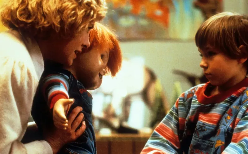 A scene from the horror movie Chucky of a Mum showing a doll to her son