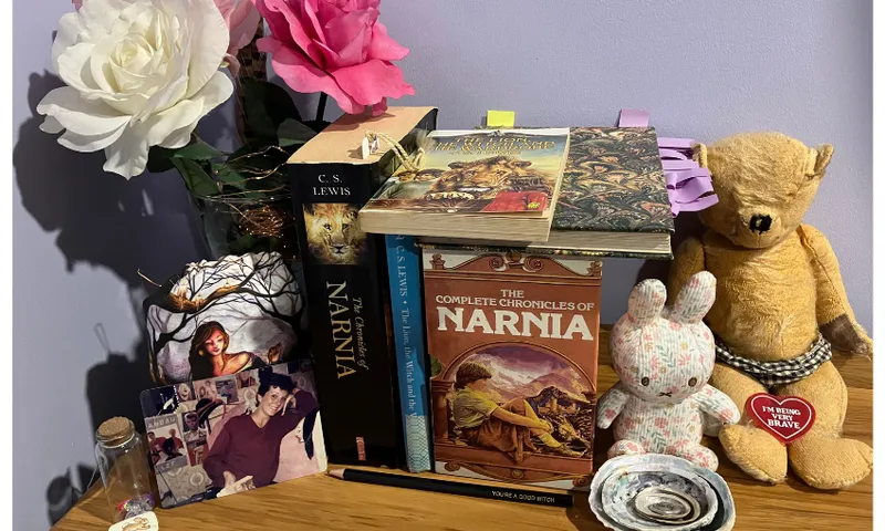 An arrangement of Narnia books with soft toys and flowers around them, like a shrine.