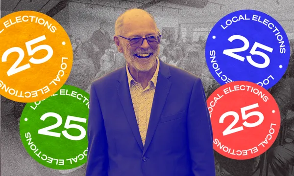 A smiling older man in glasses and a blazer stands in front of a black-and-white crowd. Colorful circular labels with "25 LOCAL ELECTIONS" are overlaid on the image in orange, green, and blue.