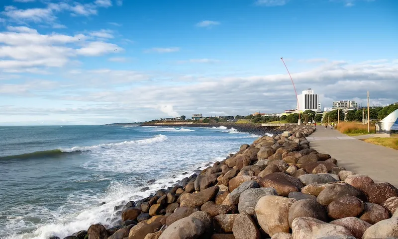 A landscape image of New Plymouth's coastal walkway, looking north, with the Len Lye Wind Wand in the distance