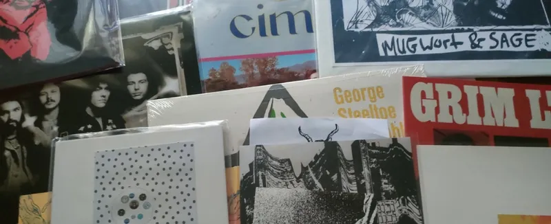 A photograph of a pile of vinyl records.
