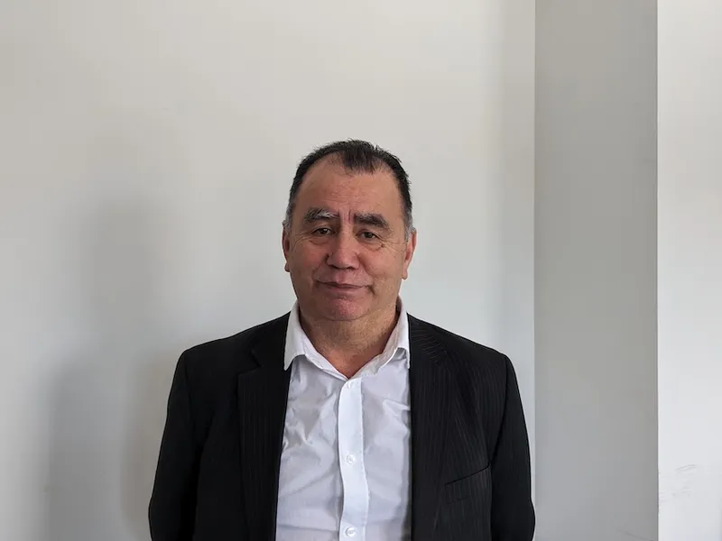 a maori man in a whit shirt with a black blazer