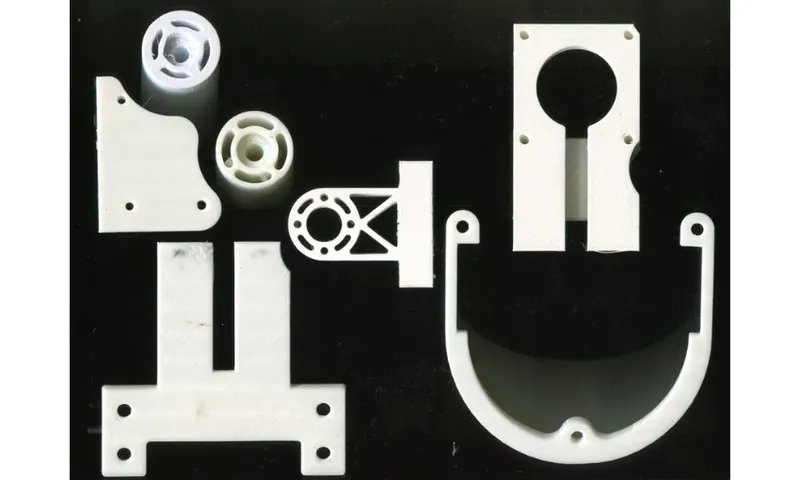 A photograph of intricately carved objects that look like machine parts. They're laid on a dark background and are ivory in colour.