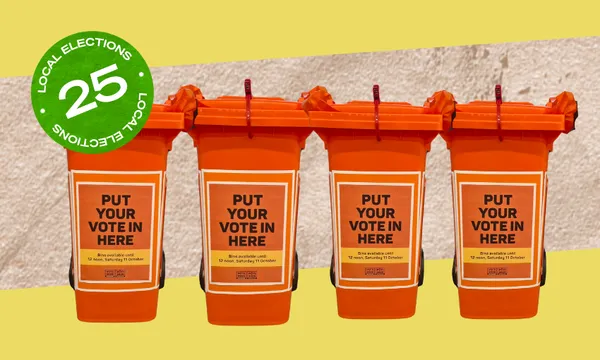 Four orange ballot bins in a row against a yellow background