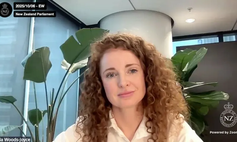 Australia woman with curly hair sits in a Zoom meeting.