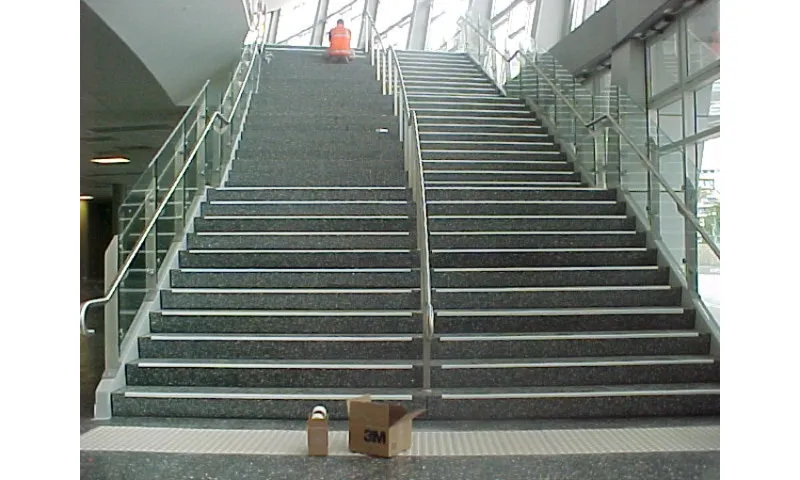 stairs where some have qhite tape and are easy to see and some don't and are hard to make out