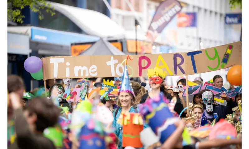 A photo of a street party where someone has made a sign on cardboard that says ' Time to Party'.