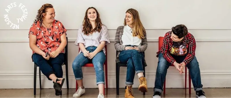 Four young people sitting side by side and talking to each other.