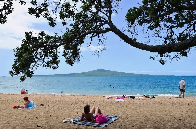 People sunbathing and swimming in Devonport beach Auckland