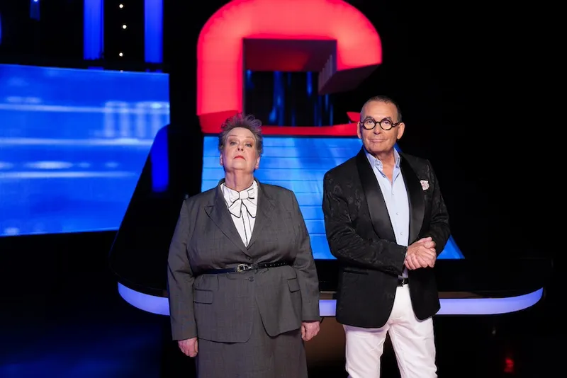 The Governess Anne Hegerty and Paul Henry stand together on the set of The Chase NZ