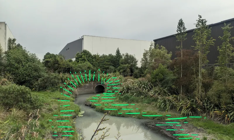 a stream coming out of the pipe with green lines around it to highlight it and some plants around