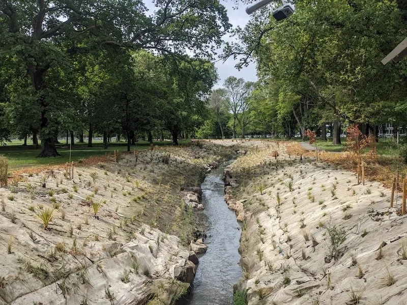 a stream which is pretty straight with lots of plants and wool matting on the side