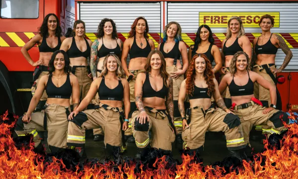 A group photos of women firefighters smiling for the camera wearing firefighting pants and black sports bras