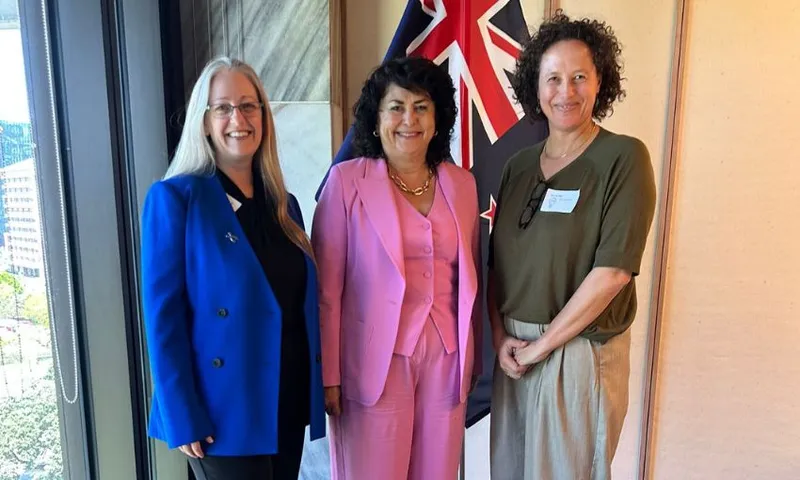 Helen Joyce, Casey Costello and Jilliane Heather stand smiling together in Costello's office.