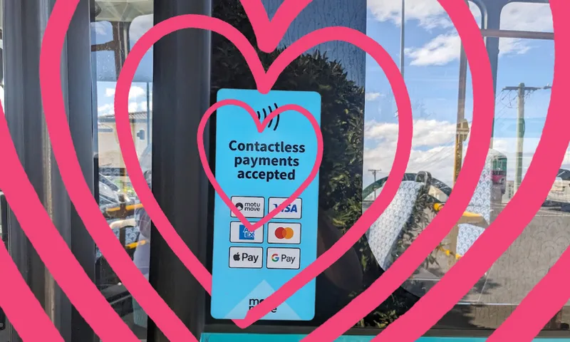 a "pay contactless" sticker on a bus door surrounded by pink hearts