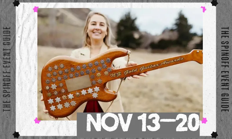 A photo of a woman holding out a guitar adorned with gold and silver stars.