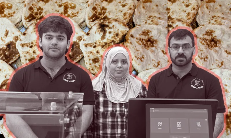 Three people wearing dark shirts and standing behind a counter, with a woman in a headscarf between two men, set against a background filled with flatbread.