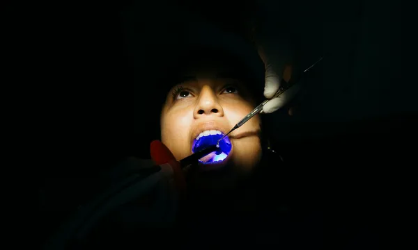 Dentist filling tooth of a young girl