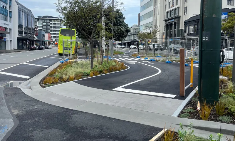 A photo of the golden mile, a cycleway on a traffic island between Kent and Cambridge Terraces, viewed from Kent terrace. There is fencing around the road.