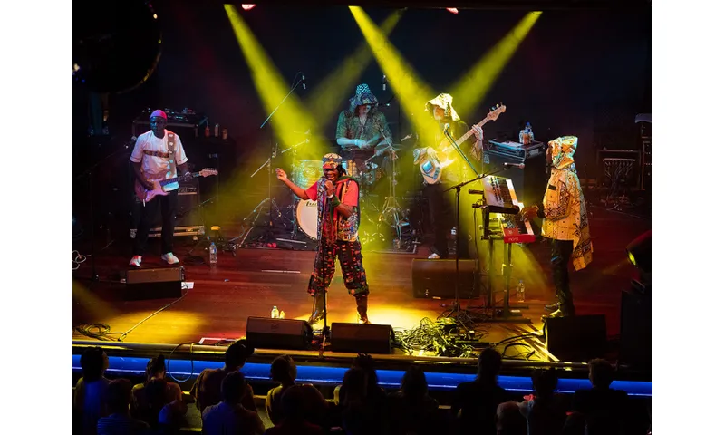 A band on stage with beams of yellow light.