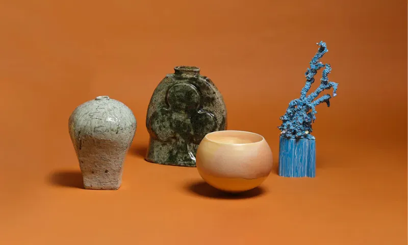 Four ceramic items arranged on terracotta surface. Each is different in shape and form and colour.