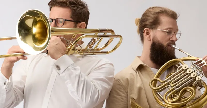 Two man playing brass instruments.