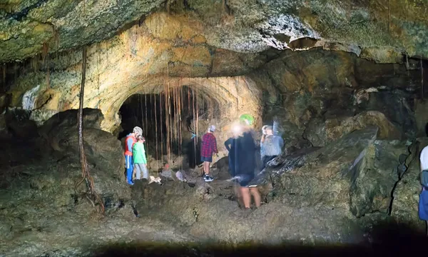 People with helmets and head torches explore a cave.