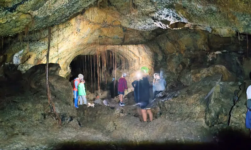 People with helmets and head torches explore a cave.