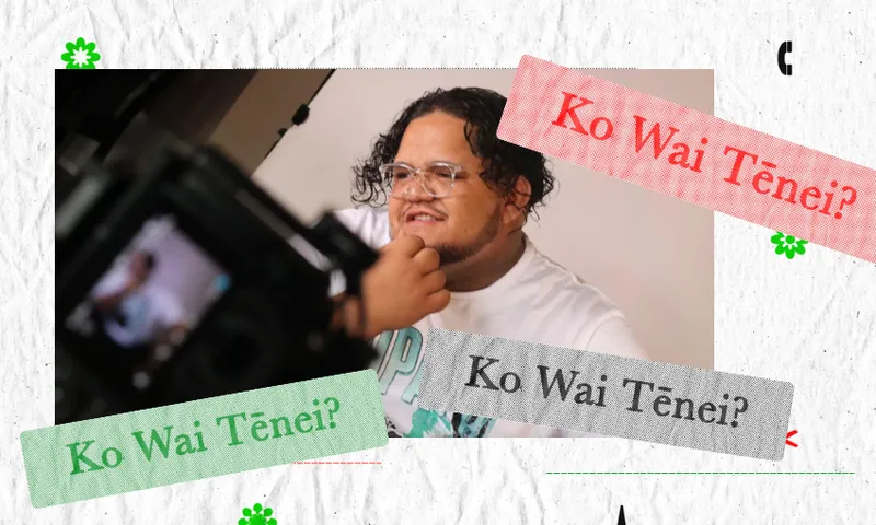 A person with curly hair, glasses, and a beard sits smiling while being filmed, with “Ko Wai Tēnei?” written in red, green, and gray text banners on the image.