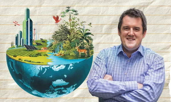 A man in a blue checkered shirt stands smiling with arms crossed next to an illustration of a half-globe featuring futuristic buildings, solar panels, farmland, forest, and wildlife on a lined-paper background.