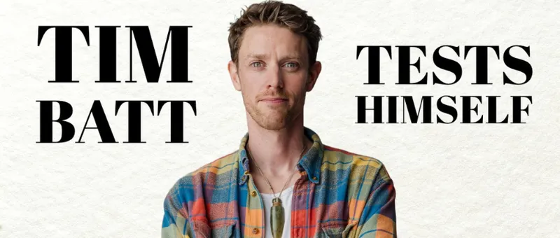 A poster for Tim Batt Tests Himself, a comedy show, which shoes the comedian's head and shoulders. He is wearing a check shirt.