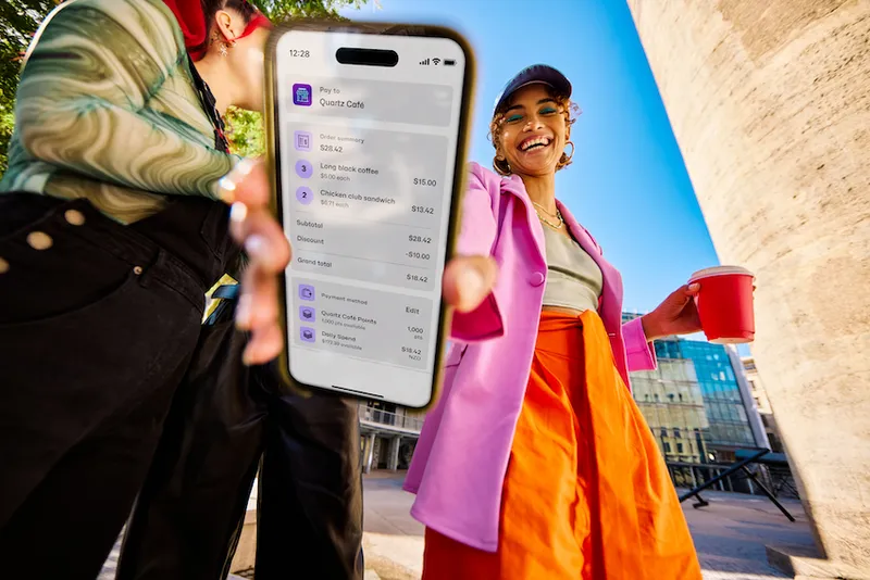 a brown woman in colourful clothing showing her phone with a discount after paying through Payap