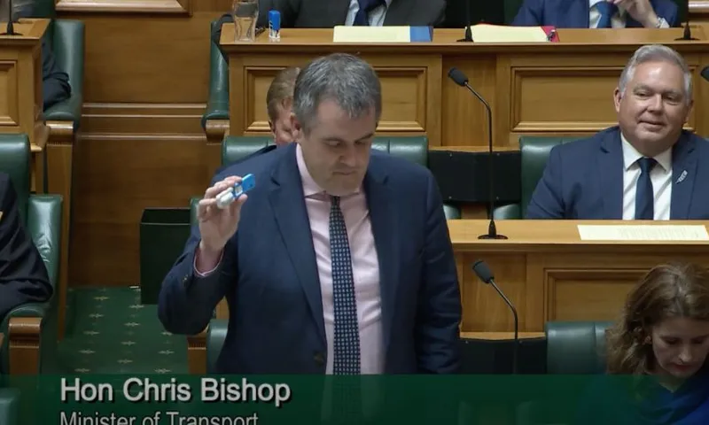 Chris Bishop stands behind his bench holding a roadside drug test, which appears like a Covid-19 test, but more blue.