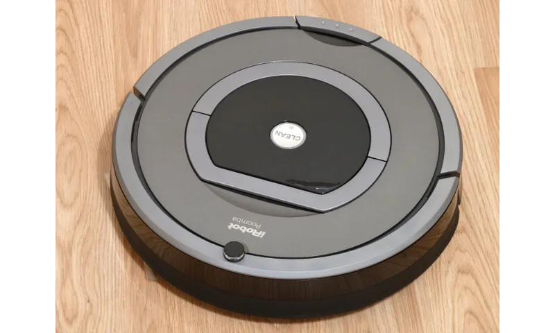 A photograph of a robotic vacuum cleaner sitting on a wooden floor.