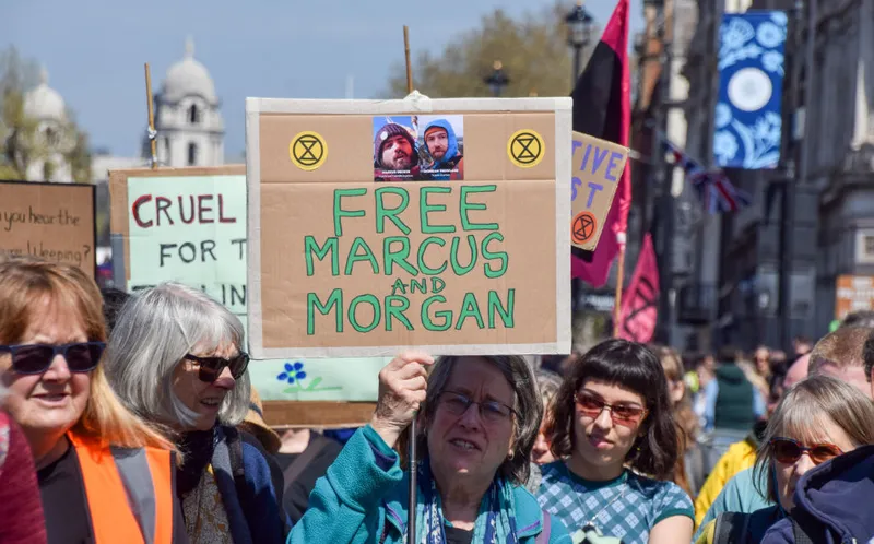 A protester holds a "Free Marcus and Morgan" placard during
