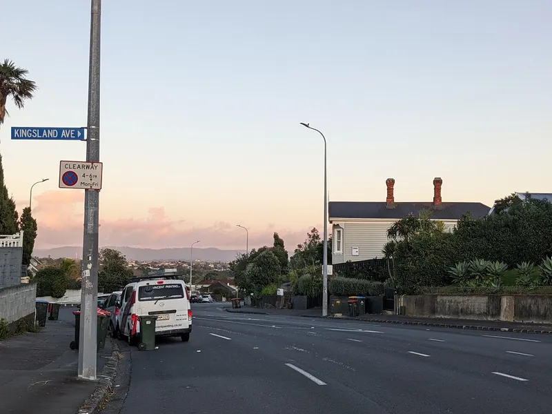 a road with a pinkish cloudy sky and the street stretching away