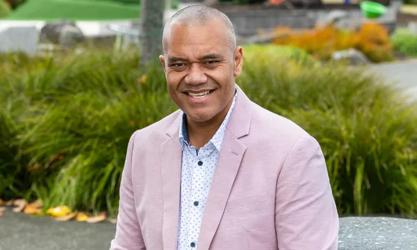 Efeso collins with a few bushes in the background a pink jacket